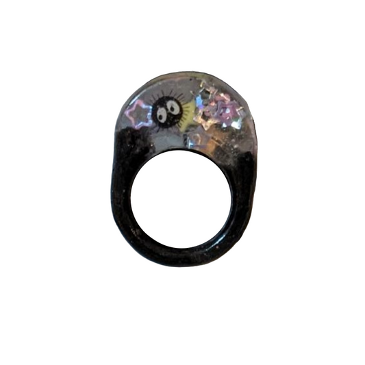 Decorative ring with cartoon character design on a patterned card